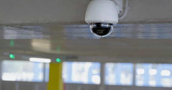 Close-up of surveillance camera in underground parking space.