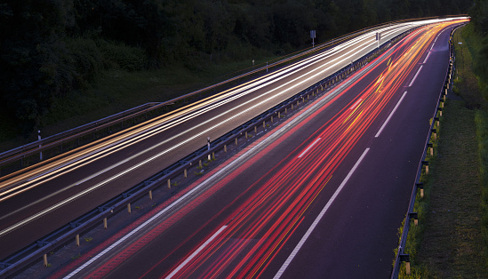 Long exposure of car lights on motorway meandering through Hills in Bavaria, Germany.