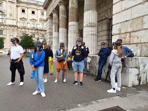 Vienna, Austria - June 7, 2023: people is enjoying watching virtual reality (VR) headsets  in front of the Hofburg Palace in Vienna, Austria.