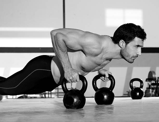 academia flexão de força homem pushup com kettlebell - human muscle body building exercising black and white - fotografias e filmes do acervo