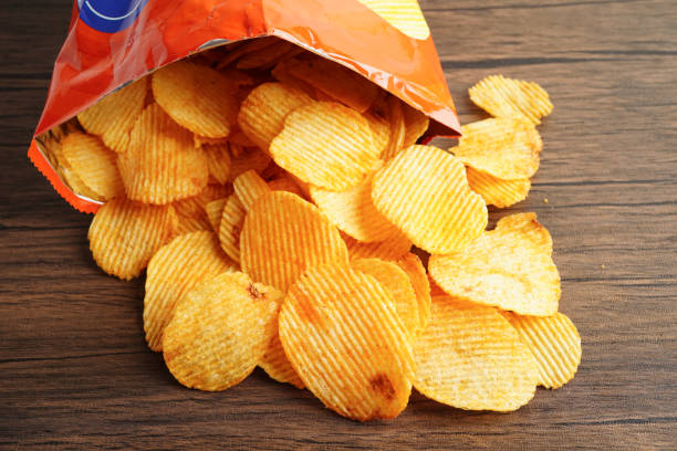 istock Potato chips in open bag, delicious BBQ seasoning spicy for crips, thin slice deep fried snack fast food. 1592046102