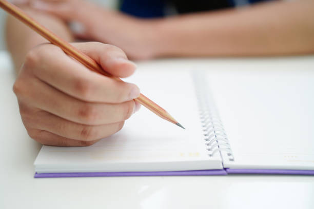 istock Asian teenage student write homework, study lesson for exam online learning education. 1592046641