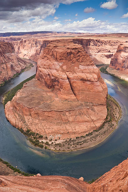 Horseshoe Bend in the Colorado River The Colorado River provides some incredible natural vistas along its length. One of the more unusual vistas is at Horseshoe Bend. The name was inspired by its unusual shape, a horseshoe-shaped meander of the river. Horseshoe Bend, located about four miles southwest of Page, Arizona, USA within the Glen Canyon National Recreation Area has become a very popular tourist attraction. glen canyon stock pictures, royalty-free photos & images