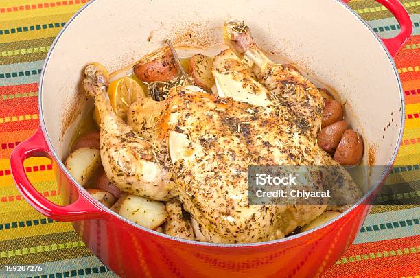 Dutch Horno Pollo A La Parrilla Con Hierbas Y Limón Foto de stock y más banco de imágenes de Olla de hierro