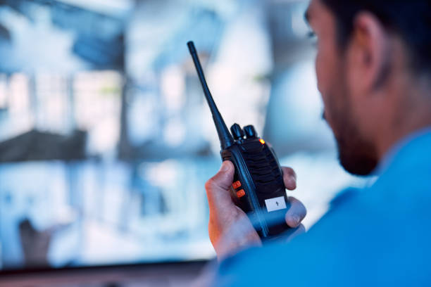 Security guard, radio and cctv monitor, communication and inspection service for building safety. Screen, video surveillance agency and law officer in control room talking on two way intercom system. guardia de seguridad, monitor de radio y cctv, servicio de comunicación e inspección para la seguridad de los edificios. pantalla, agencia de videovigilancia y oficial de la ley en la sala de control hablando en un sistema de intercomunicación bidirecci