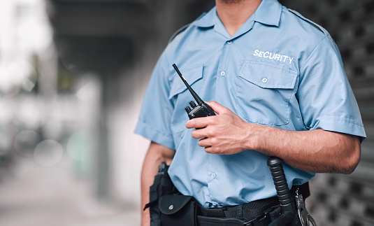 Walkie talkie, security guard or safety officer man on the street for protection, patrol or watch. Law enforcement, hand and duty with a crime prevention male worker in uniform in the city