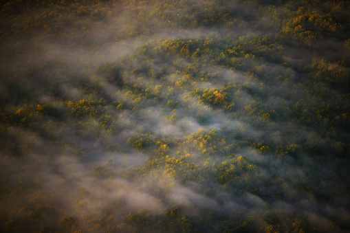 High angle perspective from hot air balloon floating over lush landscape of comarca in Girona, Catalonia.