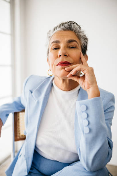 istock Strong and elegance: Mature woman sits in her office, dressed in a suit 1592133798