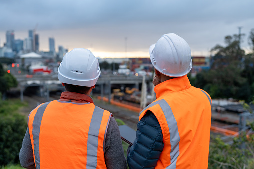 mature construction workers overlooking a construction site