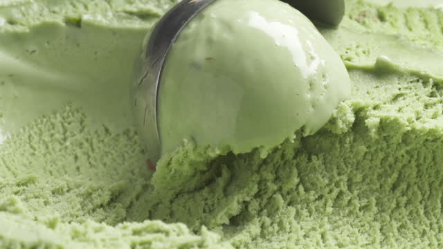 Slow motion of pistachio ice cream being scooped close up