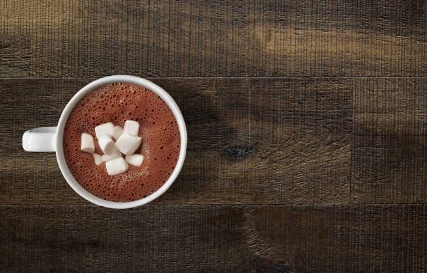 Hot chocolate on wooden table top Looking down on hot chocolate mug with marshmallows on wooden table top froth decoration stock pictures, royalty-free photos & images