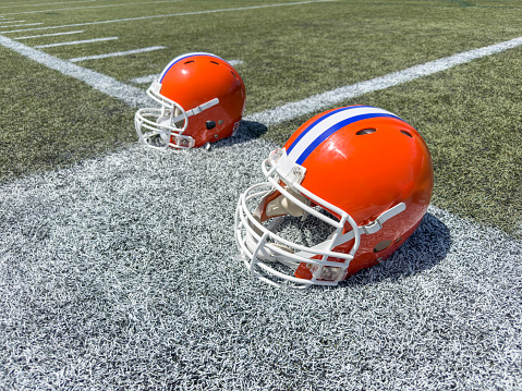 American football helmets in a practice field on a summer day
