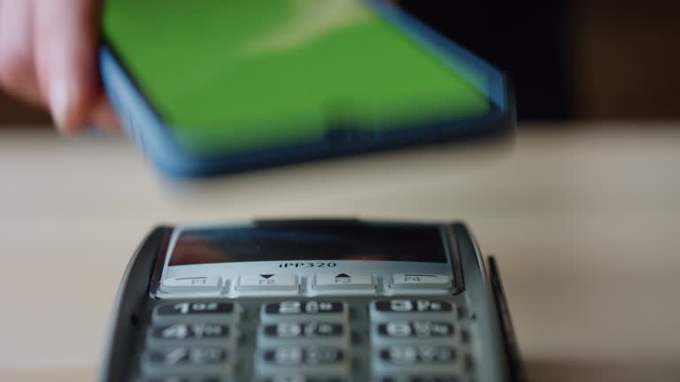 Contactless pay using phone with chroma key screen at bank pos terminal close up