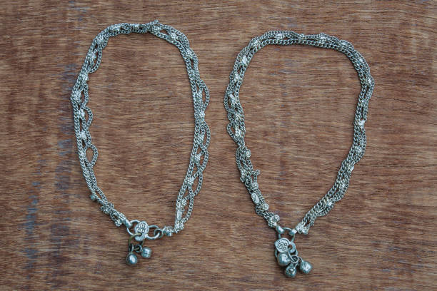 istock Silver anklet bracelets on the wooden background 1592201721