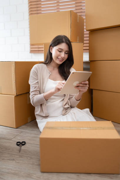 istock Beautiful woman use tablet computer shopping online with cardboard box 1592209331