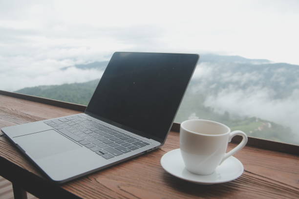 istock Young man freelancer traveler wearing hat anywhere working online using laptop and enjoying mountains view 1592210977