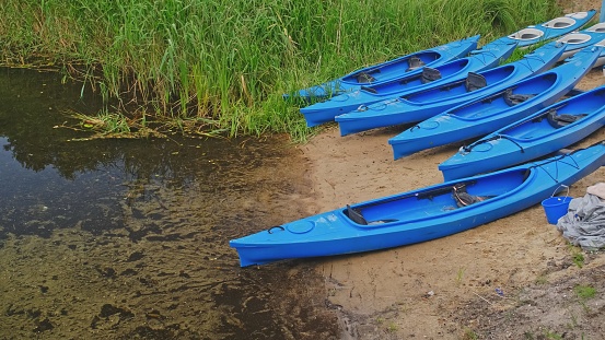 Blue Plastic Kayak at Water Sports Equipment Rental Place Marina Harbour on River Bank
