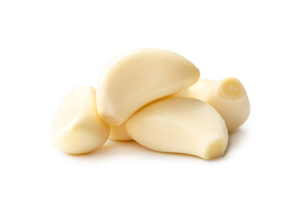istock Fresh beautiful whole peeled garlic cloves in stack isolated on white background with clipping path. 1592231437