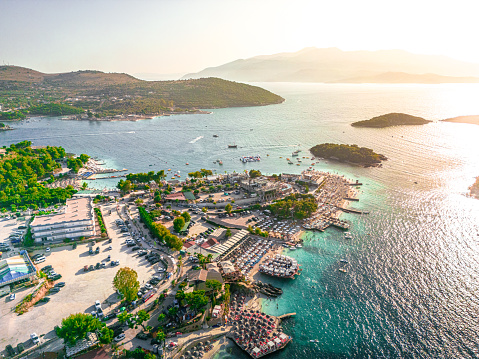 Aerial view of a crowded sand beach with umbrellas and lots of people at sunset. Albania, Dhermi and Ksamil. The islets of Ksamil, consist of four rocky islets located in direct proximity to the Ionian Sea in southern Albania.