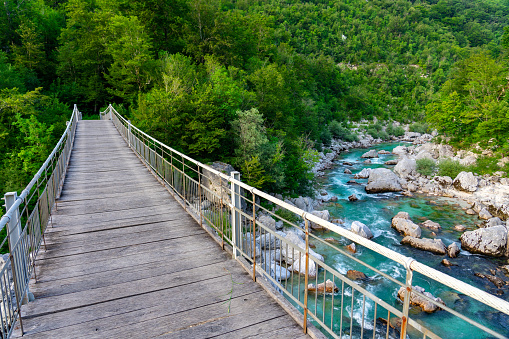 crystal clear turquoise Soca river in Slovenia near Kobarid and Bovec famous for sport activities rafting kayaking with bridge .