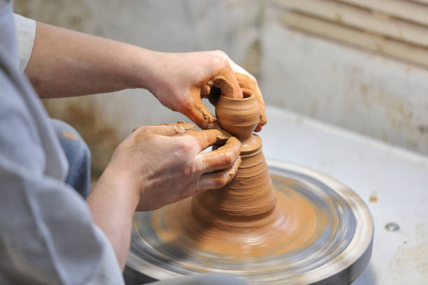 istock Potter at work. Potter making a pitcher of clay on a pottery wheel. 1592263298