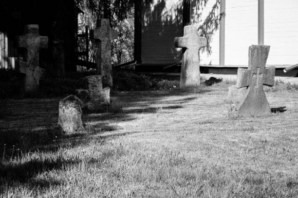 istock Old stone gravestones in the old abandoned cemetery. Black and white tone 1592297879