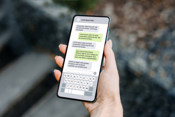 istock Woman holdind smartphone and texting outdoors. chatting with a phone 1592298556
