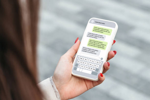 istock Woman holdind smartphone and texting outdoors. chatting with a phone 1592298559