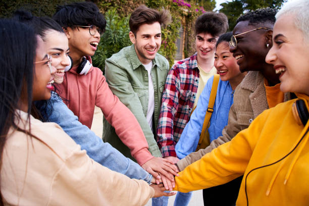 istock Multirracial group of cheerful students holding hands outdoors. Multi-ethnic young boys and girls 1592300766