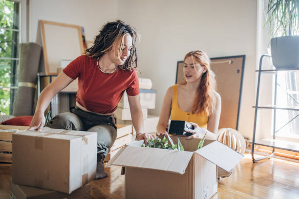 istock Lesbian couple moving in new apartment 1592300778