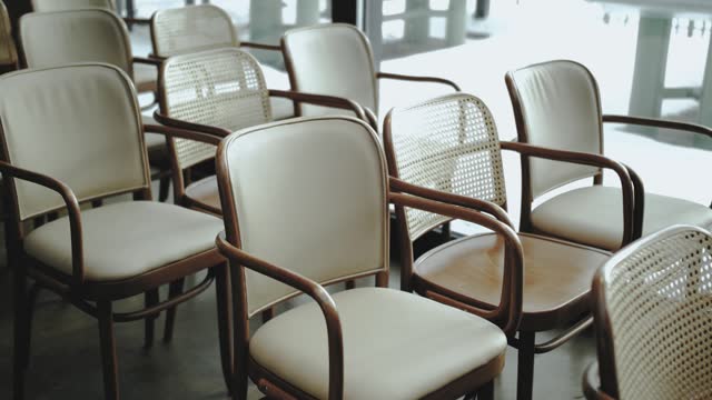 Close-up cream-colored wooden chairs on the wedding, indoor wedding celebration. Rustic wedding.