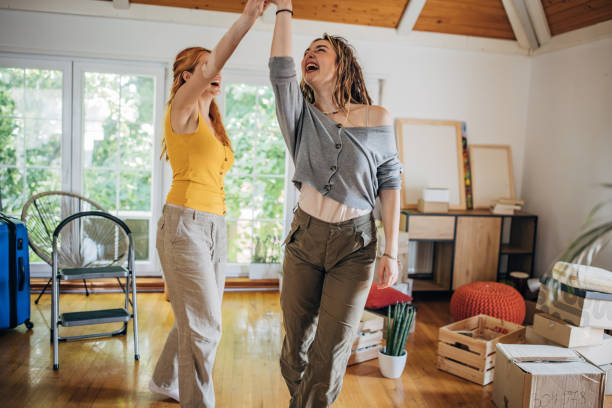 istock Lesbian couple dancing in new home 1592337532