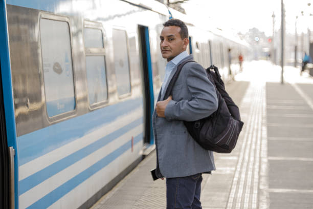 istock Latin man in a suit waiting at train station. 1592357464