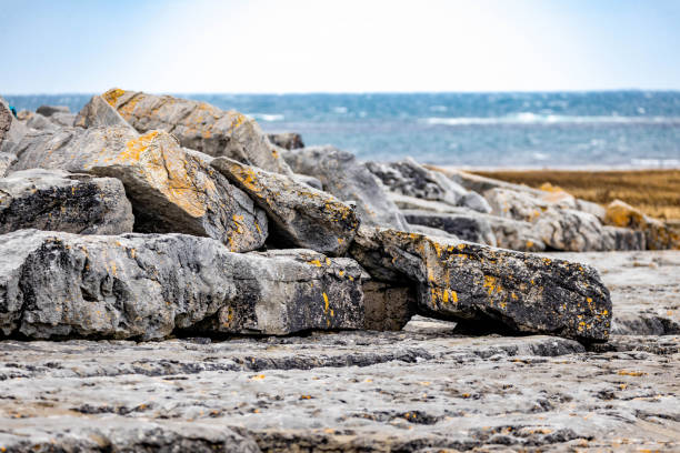 On the shore of Hudson Bay in Churchill, an Inukshuk rises above the rocky beach in Churchill, Manitoba.