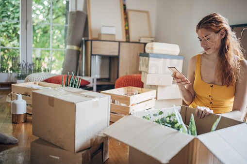 One woman, young woman unpacking in her new apartment.