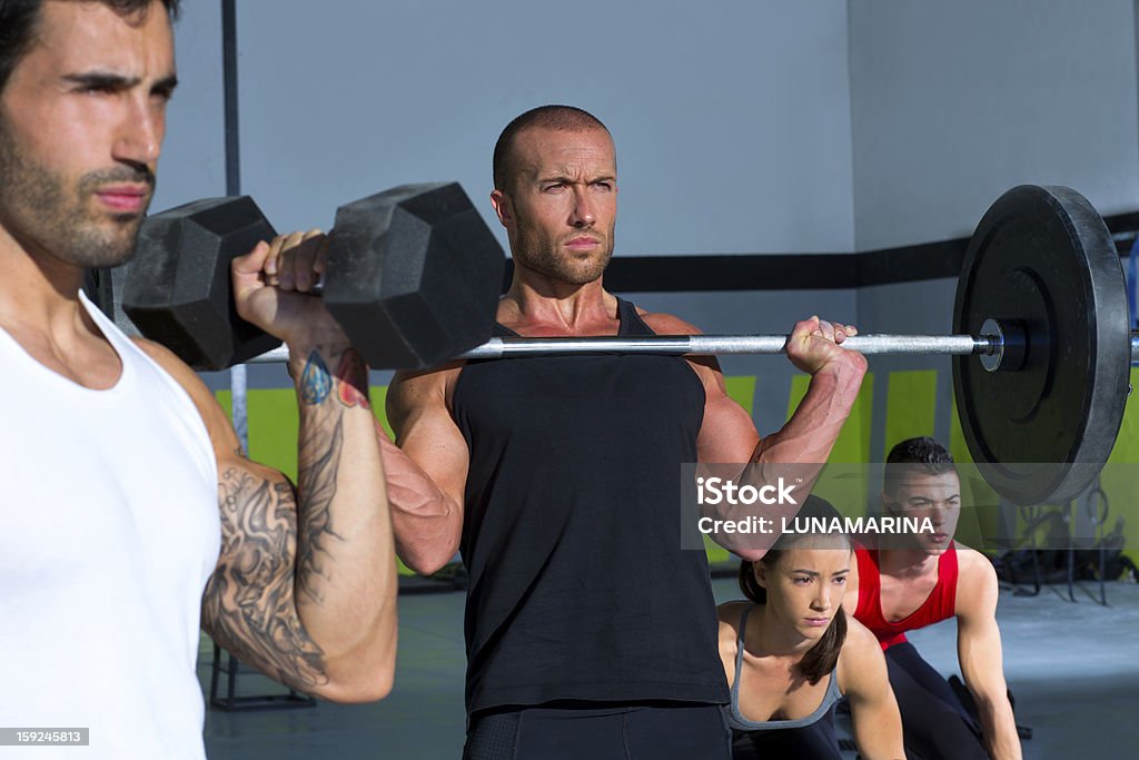 Grupo de levantamiento de gimnasio con pesas barra crossfit entrenamiento - Foto de stock de 20 a 29 años libre de derechos