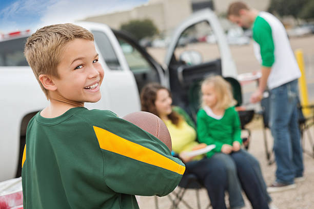 Happy little boy tailgating with family near college football stadium Happy little boy tailgating with family near college football stadium.  people family tailgate party outdoors stock pictures, royalty-free photos & images