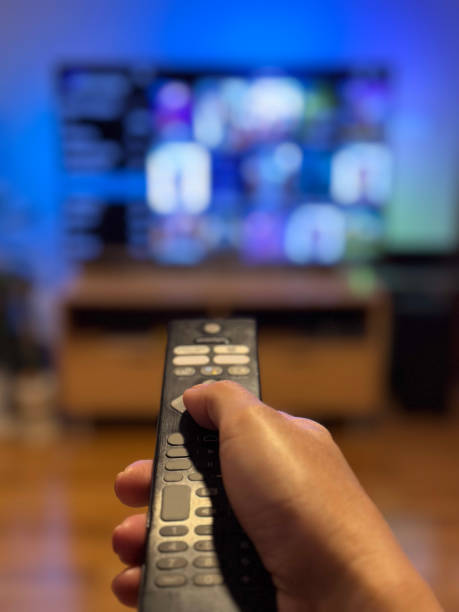 Hand holding a remote control stock photo