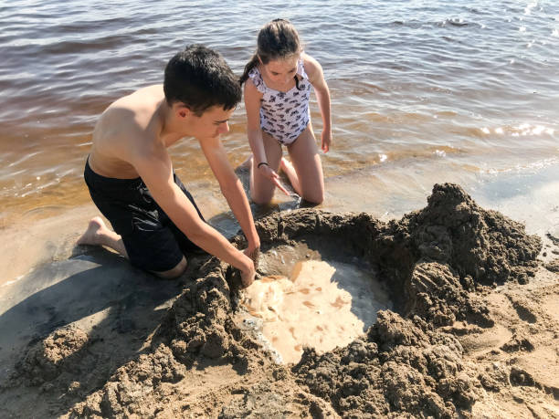 istock Brother and sister making castle sand 1592511671