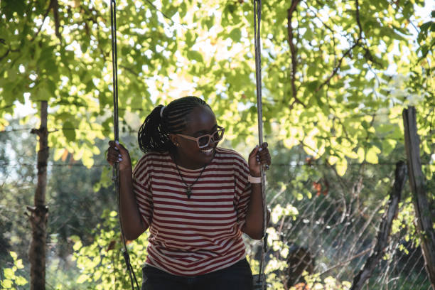 istock Enjoying day in the park swinging 1592515898