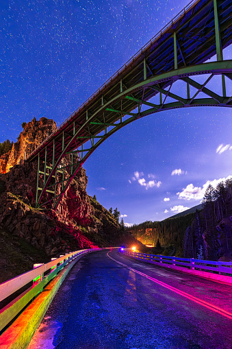 Red Cliff Bridge Spanning Sky at Night - Scenic high bridge connecting canyon mountain area in Red Cliff, Colorado USA. Night photography with light painting and creative lighting. Below the top of Battle Mountain Pass going between Minturn and Red Cliff.