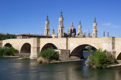 View of the basilica of the Virgen del Pilar and Ebro river, on the right is located the medieval bridge called Puente de Piedra, Zaragoza, Aragon, Spain