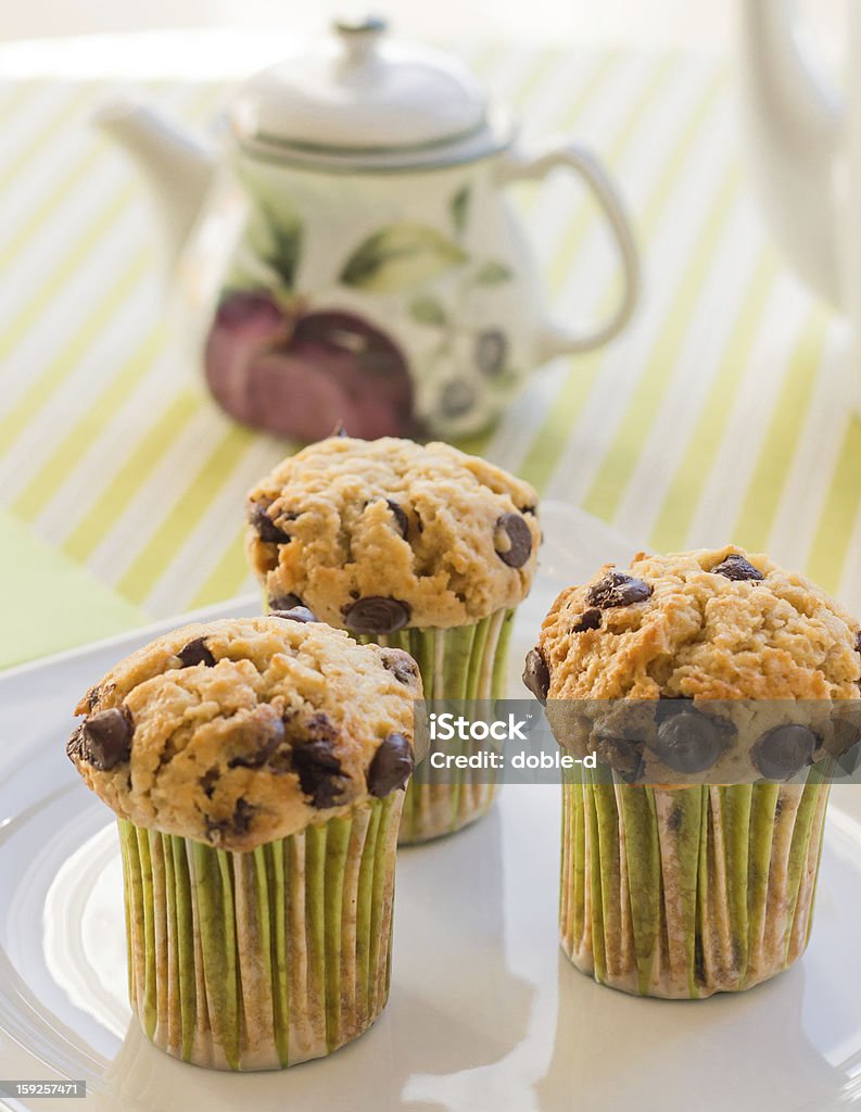 Chocolate chip-muffins auf weißem Teller und grün gestreifte tableclo - Lizenzfrei Braun Stock-Foto