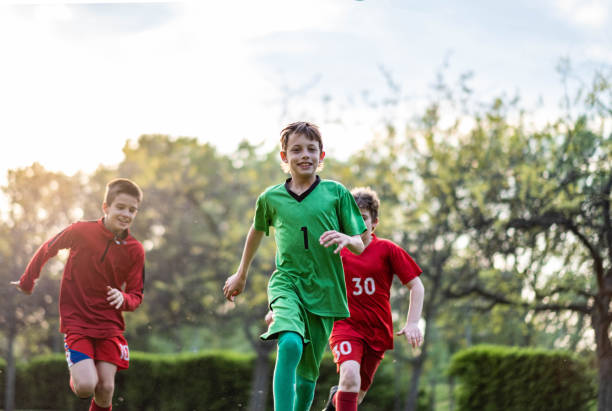 istock three football players running on the grass 1592609191