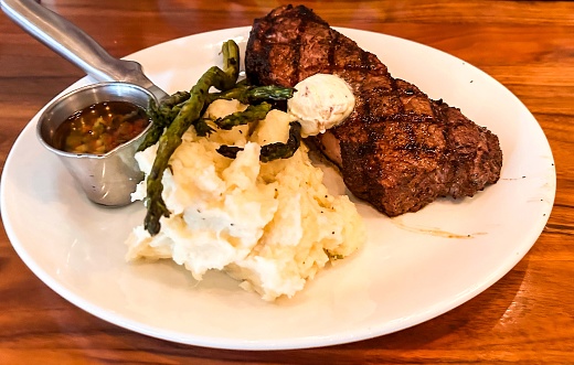 New York Strip Steak Dinner with garlic mashed potatoes, asparagus, and bone marrow butter