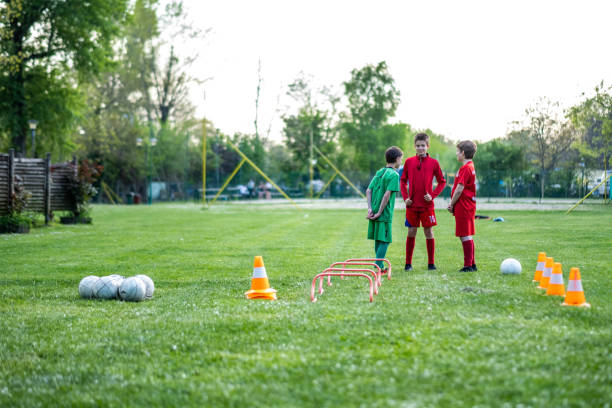 istock three football players train on the grass 1592625717