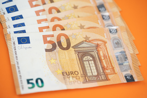 50 euro bills on an orange background