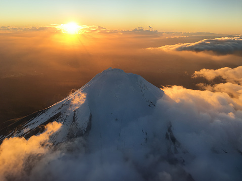 Magical sunrise over the snow-covered summit of Mt Taranaki in New Zealand's North Island, taken from an airplane