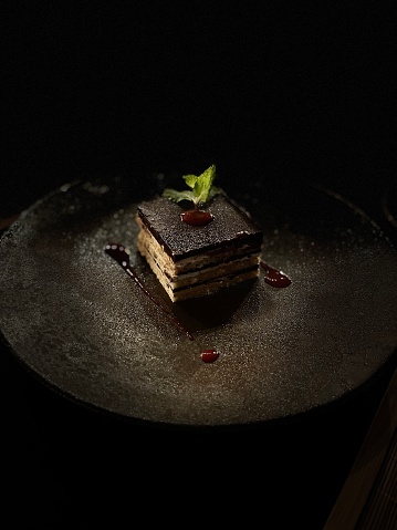 The perfect piece of chocolate cake, professionally plated with dark background