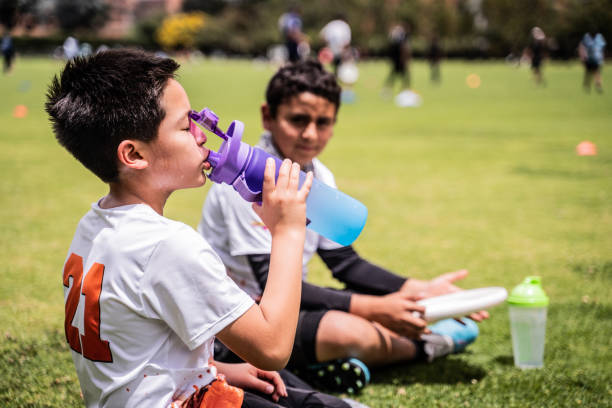istock Boy drinking water at the public park 1592659194